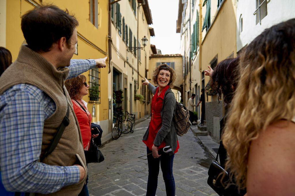 Group of people walking down a cobblestone street in Florence