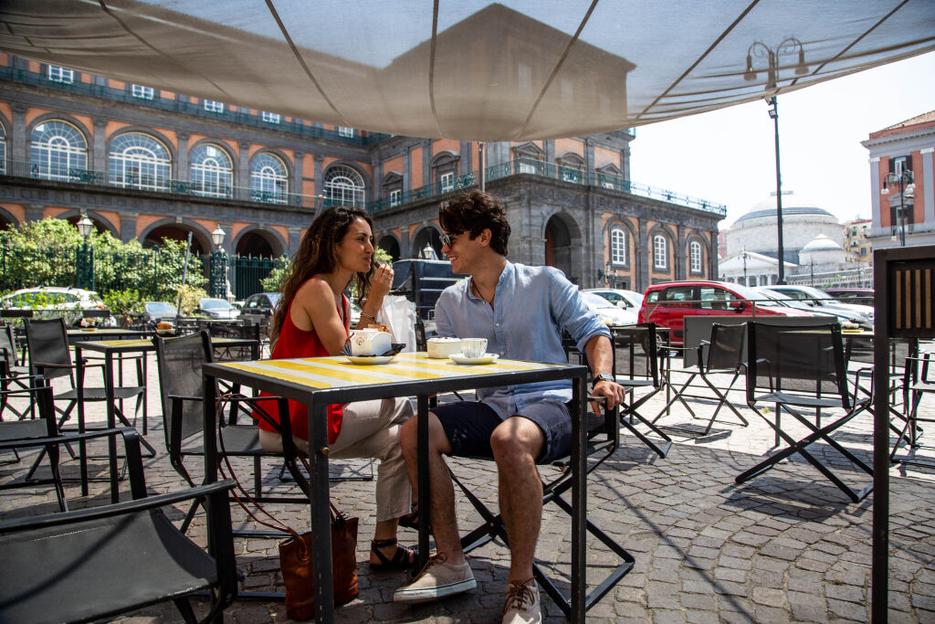 a couple enjoy an espresso on an italian cafe patio