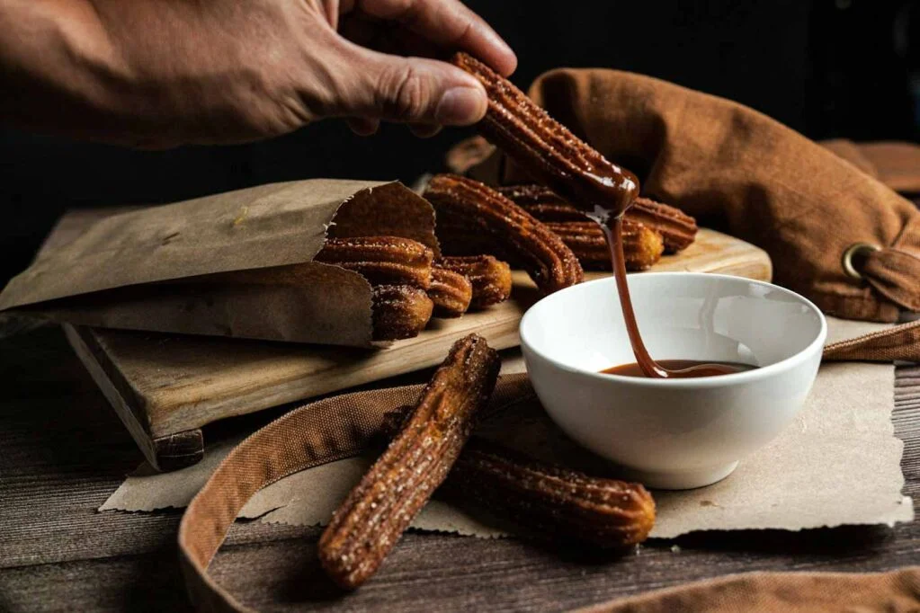 Person_dipping_churros_into_sauce_Barcelona