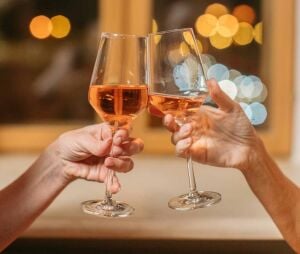 two_people_clinking_glasses_of_orange_wine_seville