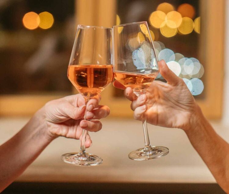 two_people_clinking_glasses_of_orange_wine_seville